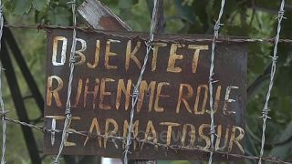 A sign at the former weapons factory in Polican, saying "The facility is being protected by armed guards".