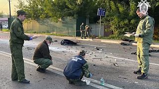 Investigators work on the site of explosion of a car driven by Daria Dugina outside Moscow, 21 August 2022
