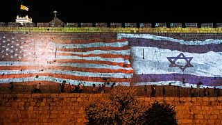 تصویری از پرچم اسرائيل و آمریکا بر روی دیواری در شهر بیت‌المقدس 