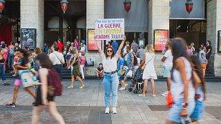 Diana Dimitrova, une Ukrainienne, tient une pancarte en français "Pour ceux qui ont oublié : la guerre en Ukraine continue toujours". Lyon, France, août 2022