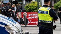 Ein Polizist sichert den Tatort vor das Einkaufszentrum in Malmö, in dem ein Mensch durch Schüsse getötet wurde.