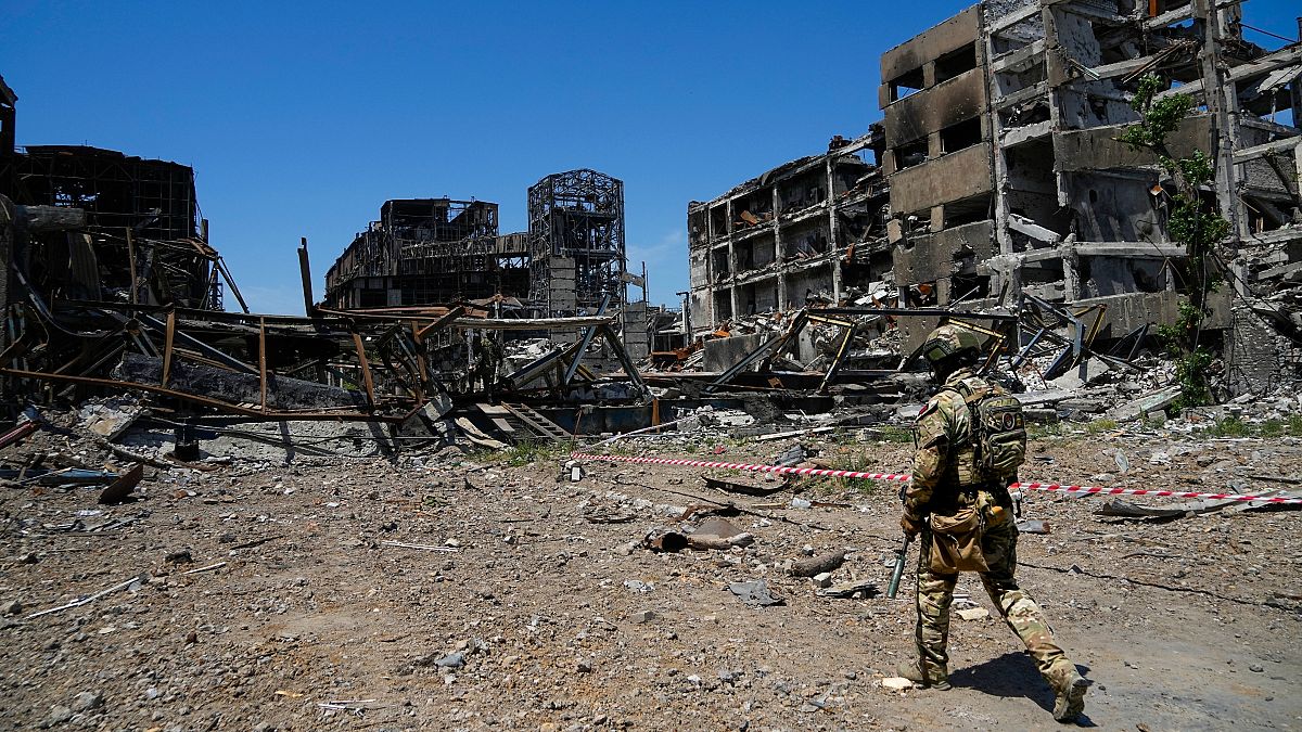 Солдат армии РФ на фоне разрушенного завода "Азовсталь" в Мариуполе