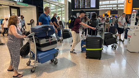 Travellers queue at Heathrow airport, in London.