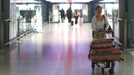 A passenger walks with her luggage through Heathrow Terminal 5 airport in London, Britain.