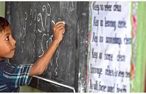طفل لاجئ من الروهينغا يكتب لغة الروهينغا على السبورة في مدرسة في مخيم كوتوبالونغ للاجئين في أوخيا.