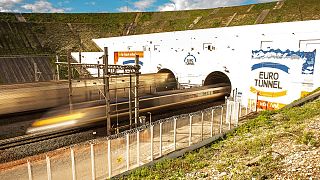 This photo taken on October 20, 2015 in Coquelles shows Eurotunnel train and shuttle entering the Eurotunnel, during the inauguration of a new Eurotunnel freight line.