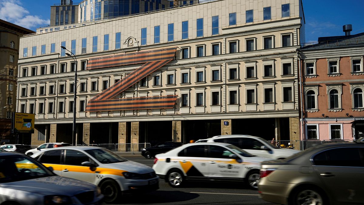 Cars drive along a street with a huge letter Z, which has become a symbol of the Russian military on a building in a street in Moscow