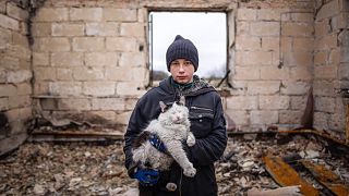 Danyk Rak, 12 ans, tenant un chat sur les débris de sa maison détruite par les bombardements russes sur le village de Novoselivka, près de Chernihiv, le 13 avril 2022