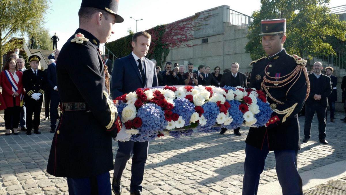 Emmanuel Macron lays a wreath at Bezons bridge near Paris, Oct. 16, 2021, the first French president to commemorate the brutal repression of an Oct 17, 1961 demonstration.