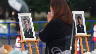 Gyászoló nő Abe Sinzó portréjánál 2022 júliusában