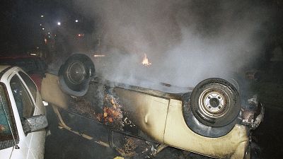 Un'auto distrutta nel quartiere di Lichtehgen, Rostock, 1992