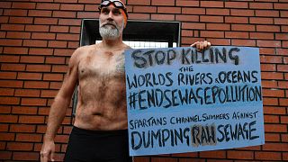 Le nageur de la Manche Peter Green proteste contre le déversement d'eaux usées brutes dans la mer, à Glasgow, le 12 novembre 2021, pendant la COP26