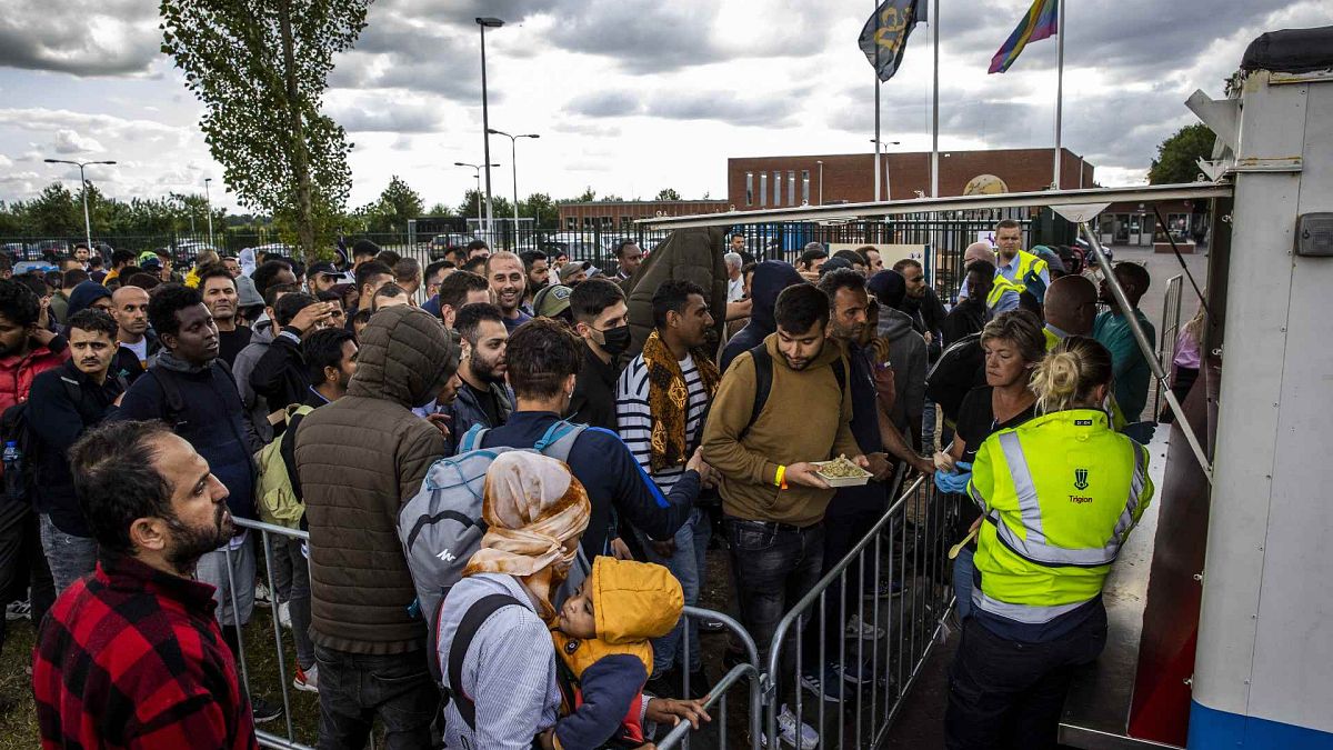 مهاجرون ينتظرون في طابور لتوزيع الطعام الساخن في مركز طلبات اللجوء في تير أبيل، هولندا، 14 يوليو 2022