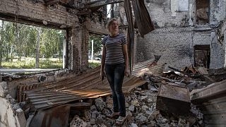 Lyudmila Holovienko stands amid the rubble of her home in the suburbs of Kyiv