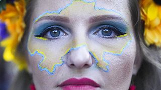 A woman made up with the outline of a map of Ukraine on her face celebrates Ukrainian Independence Day in Berlin, Germany, Wednesday, Aug. 24, 2022.