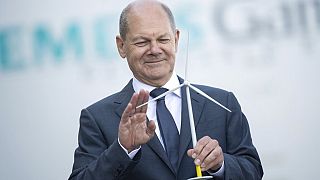 Der deutsche Bundeskanzler Olaf Scholz mit einem Modell eines Windrades