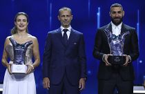 Алексия Путельяс и Карим Бензема держат свои трофеи рядом с президентом УЕФА Александером Чеферином
