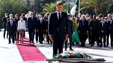 French President Emmanuel Macron pays his respect after laying a floral wreath at the Martyrs Monument in Algiers on August 25, 2022.