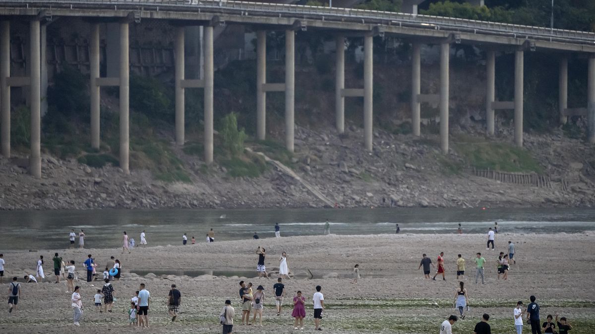 Жители города Чунцин гуляют там, где раньше протекал приток реки Янцзы. 20 августа 2022.