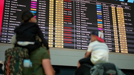 Passengers look at flights timetables in Rome's Leonardo Da Vinci international airport.