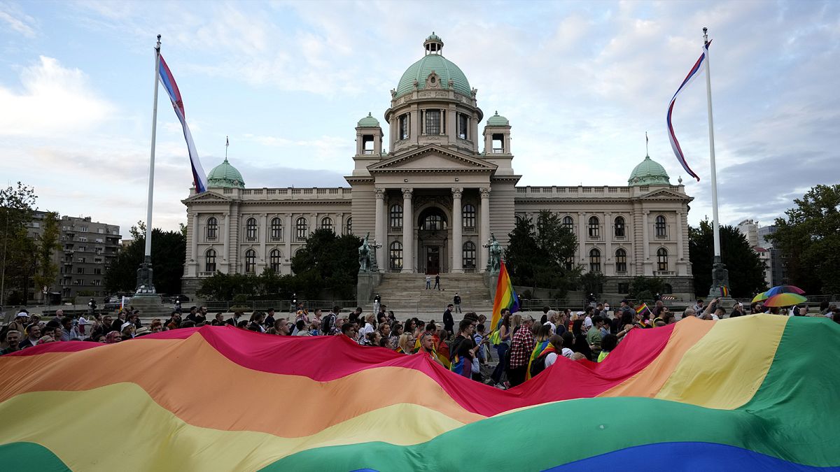 Participants carry large rainbow flag in front of the parliament building as they take part in the annual LGBT pride march in Belgrade, 19 September 2021