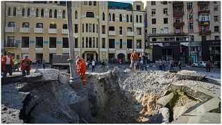 حفرة ناتجة عن هجوم صاروخي روسي قرب المباني المتضررة في وسط مدينة خاركيف