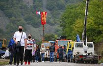 Észak-koszovói szerbek gyalogolnak át a határon, megkerülve a barikádokat 2021 nyarán.