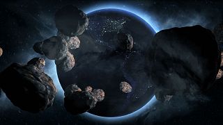 عکس تزیینی از زمین و سیارک‌هایی که به سمت زمین در حرکت هستند