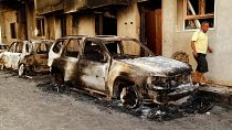 The remains of a car burned during clashes stands in a street in the Libyan capital of Tripoli, Sunday, August 28 2022.