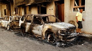 The remains of a car burned during clashes stands in a street in the Libyan capital of Tripoli, Sunday, August 28 2022.