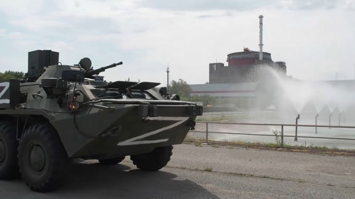A Russian tank cruises past the nuclear plant 