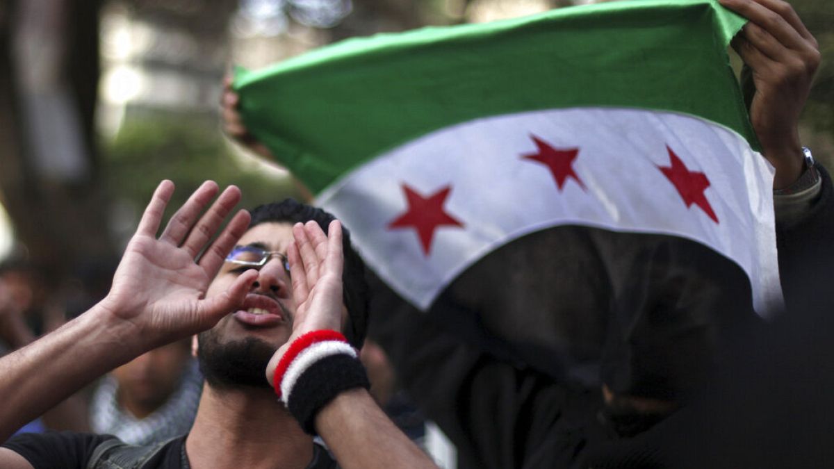 متظاهرون يلوحون بعلم الثورة السورية خلال مسيرة بعد صلاة الجمعة في الجامع الأزهر في القاهرة، مصر، في 28 ديسمبر / كانون الأول 2012
