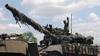 Ukrainian troop members stand on a tank on a road of the eastern Ukrainian region of Donbas on June 21, 2022.