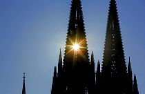 Die Sonne scheint durch einen der zwei Türme des Kölner Doms.