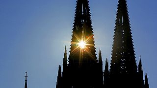 Die Sonne scheint durch einen der zwei Türme des Kölner Doms.