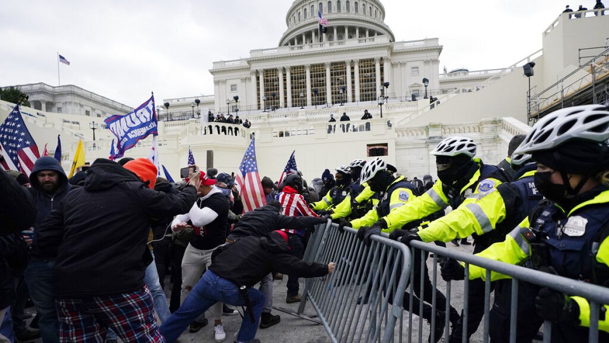 Eski ABD Başkanı Donald Trump destekçileri, 6 Ocak 2021'de Kongre binası önünde bir polis bariyerini aşmaya çalışıyor