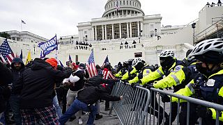 Eski ABD Başkanı Donald Trump destekçileri, 6 Ocak 2021'de Kongre binası önünde bir polis bariyerini aşmaya çalışıyor
