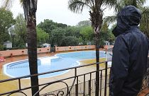 An employee looks at the deserted swimming pool in the closed campsite 'Les Galets' in Argeles-sur-Mer, 21 April 2020