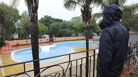 An employee looks at the deserted swimming pool in the closed campsite 'Les Galets' in Argeles-sur-Mer, 21 April 2020