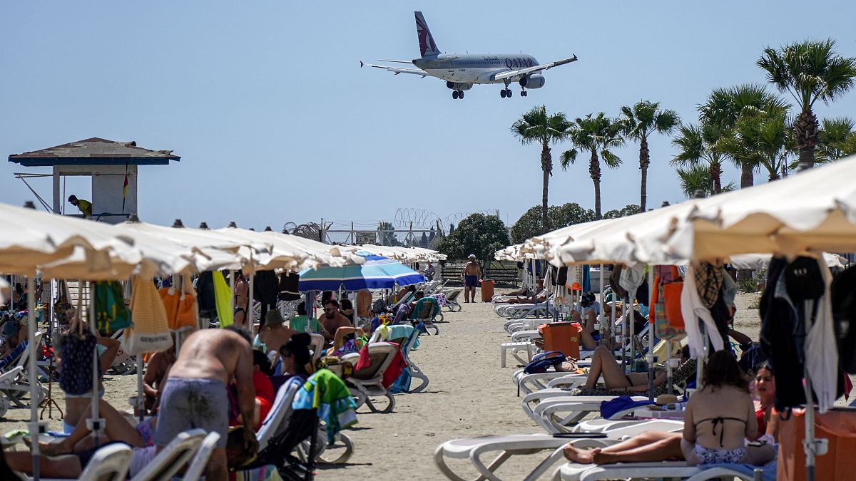 طائرة تابعة للخطوط الجوية القطرية من طراز إيرباص A320 تحلق فوق أحد الشواطئ مع اقترابها من الهبوط في مطار لارنكا الدولي في جنوب قبرص في 28 أغسطس 2022.