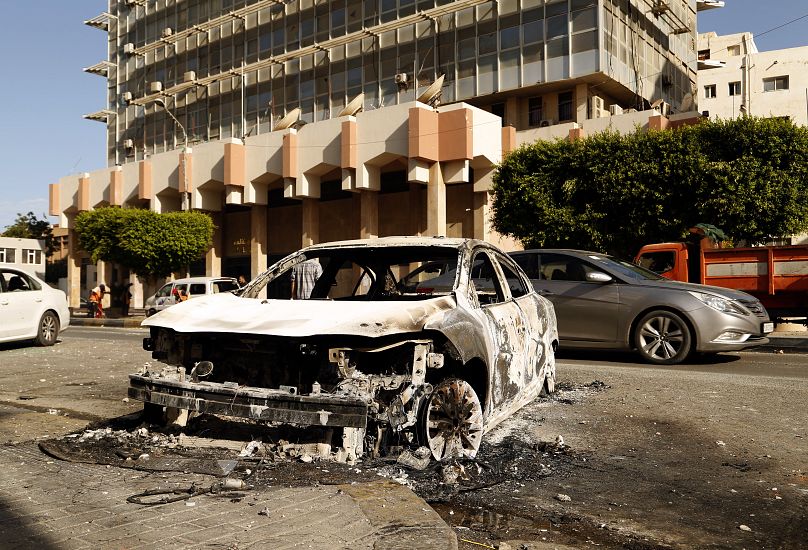 Restos de un coche en una calle de la capital libia, Trípoli, tras los enfrentamientos entre milicias rivales, 28 de agosto de 2022.