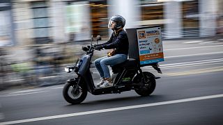 A delivery man rides a scooter in Paris, France, Tuesday, Aug. 23, 2022.