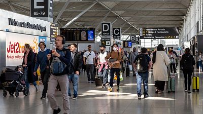 Travelers arrive at Stansted Airport in London.