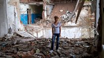 Sofia Klyshnia, 12, stands in the rubble of her former classroom in the same spot her desk was before it was bombed by Russia, Chernihiv, Ukraine, Tuesday, Aug. 30, 2022.