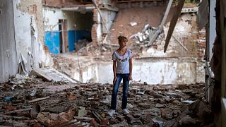Sofia Klyshnia, 12, stands in the rubble of her former classroom in the same spot her desk was before it was bombed by Russia, Chernihiv, Ukraine, Tuesday, Aug. 30, 2022.