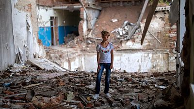 Sofia Klyshnia, 12, stands in the rubble of her former classroom in the same spot her desk was before it was bombed by Russia, Chernihiv, Ukraine, Tuesday, Aug. 30, 2022.