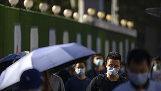 Çin'de Covid-19 nedeniyle sokakta maskeyle dolaşan vatandaşlar