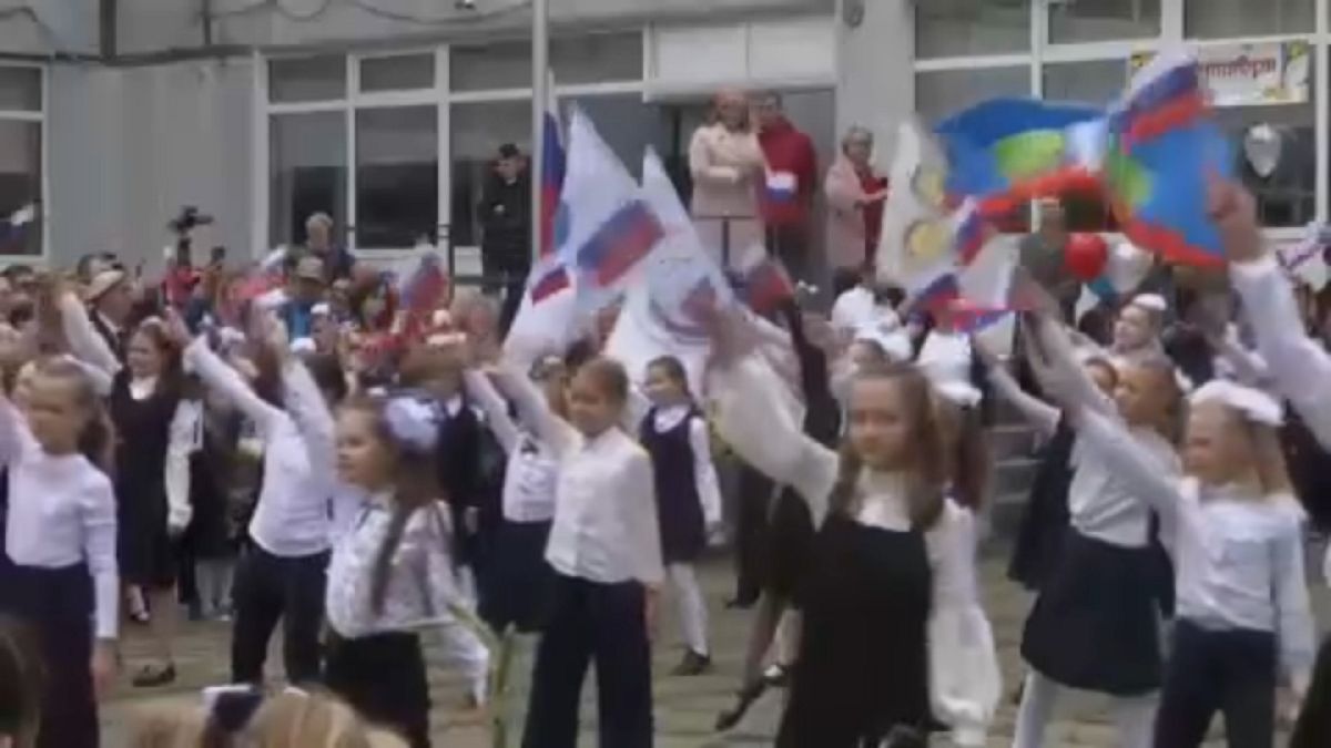 Tanulók orosz zászlókat lobogtatnak a nahabinói 3. számú általános iskola tanévnyitóján