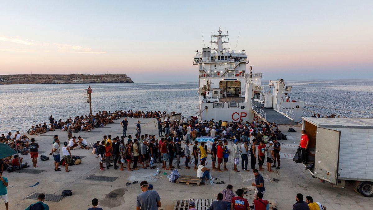 مهاجرون ينتظرون على متن سفينة تابعة لخفر السواحل الإيطالية في جزيرة لامبيدوزا الإيطالية.