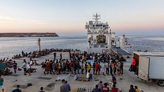 مهاجرون ينتظرون على متن سفينة تابعة لخفر السواحل الإيطالية في جزيرة لامبيدوزا الإيطالية.